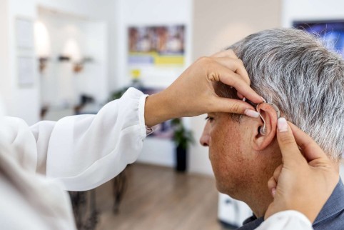 Fonoudiólogo profesional asesorando a un paciente en una clínica moderna, simbolizando la atención personalizada y profesional de American Ear