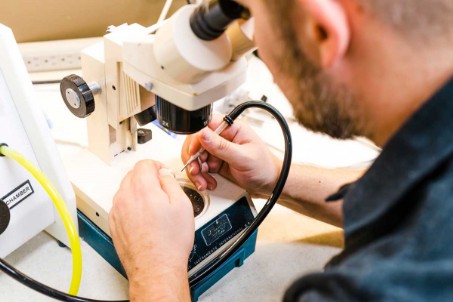 Técnico realizando limpieza profesional de audífonos en un centro especializado