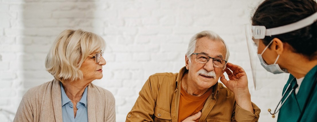 Pareja de ancianos conversando con un profesional fonoaudiólogo Una pareja de ancianos recibiendo orientación de un profesional de la salud sobre audífonos y pérdida auditiva